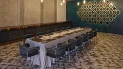 Sophisticated private dining room with long table and artistic walls - Pride Elite Gandhinagar
