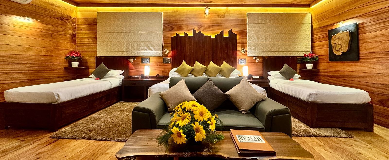 Wooden interior of a room with twin beds, a seating area, and warm lighting - BluSalzz Collection - Tranquil Resort, Wayanad