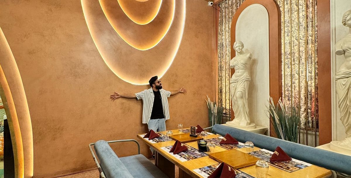 A view of the stylish interior at Themis Barbecue House, Ambala, with booth seating and decorative lighting.