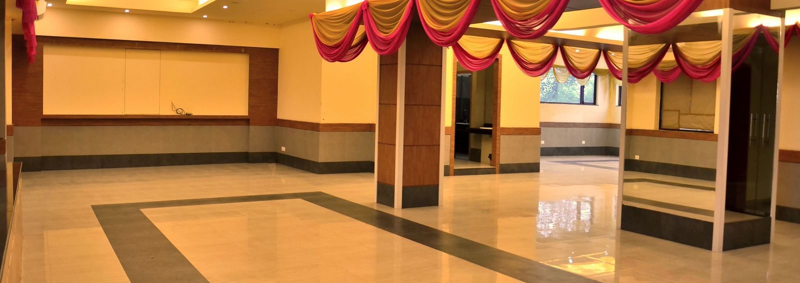 an expansive banquet hall well lit with warm lighting - Max Hotel, Jabalpur