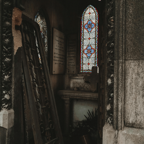 Interior view of a church showing stained glass windows and wooden furnishings.