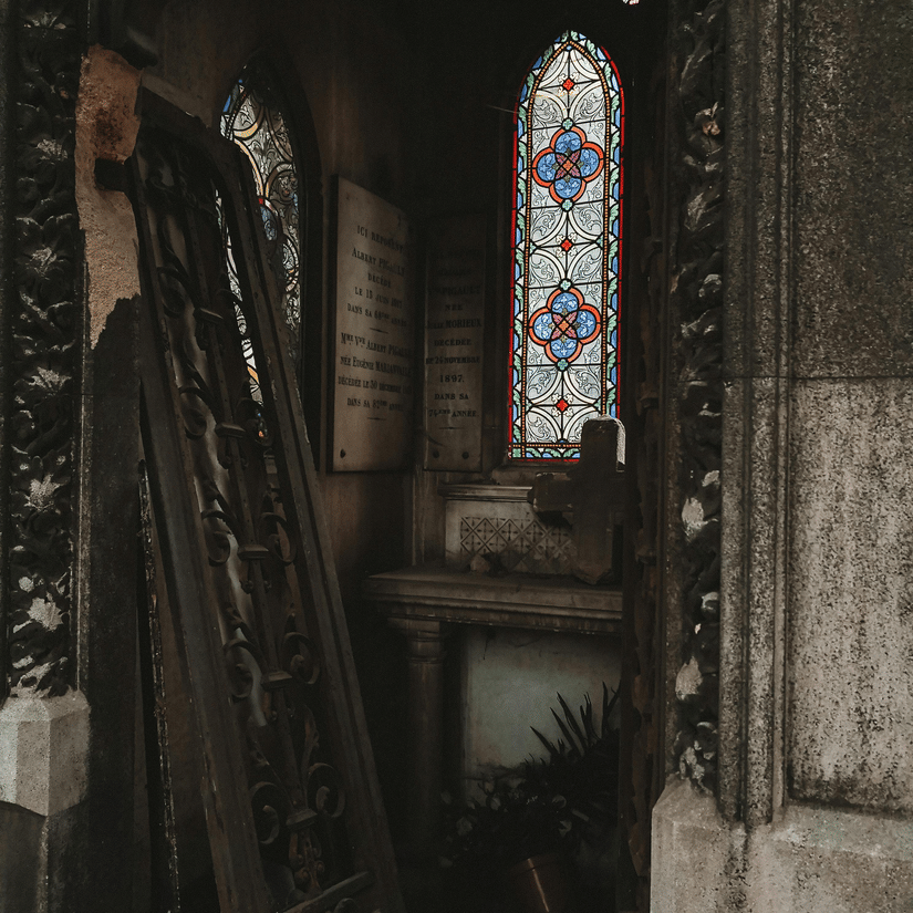 Interior view of a church showing stained glass windows and wooden furnishings.
