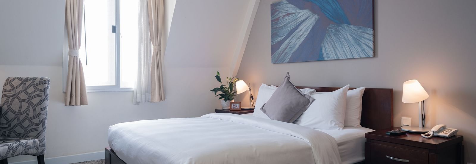 A bedroom with a large bed and a large window near it | Studio | Central Mansions, Phnom Penh