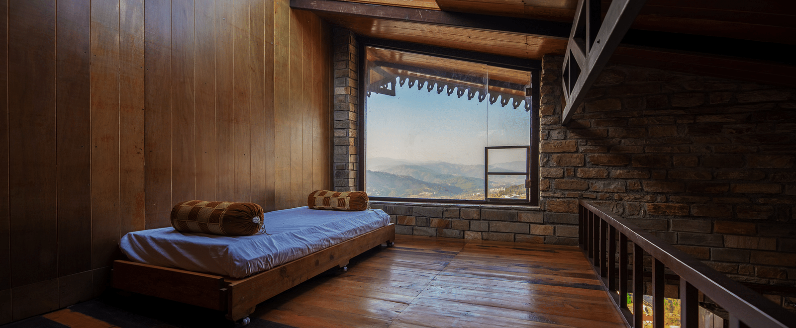 Rustic wooden interior with a bed by a large window overlooking mountains. - Blusalzz Homes The Himalayan Bungalow, Almora