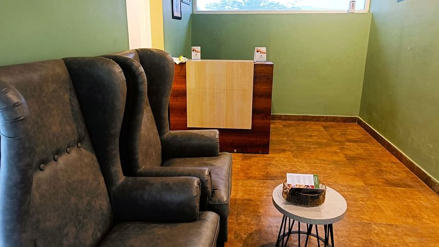 Spa reception area at DLS Forest Vines Resort featuring cushioned seating, a small sound table, and a reception desk in the corner.