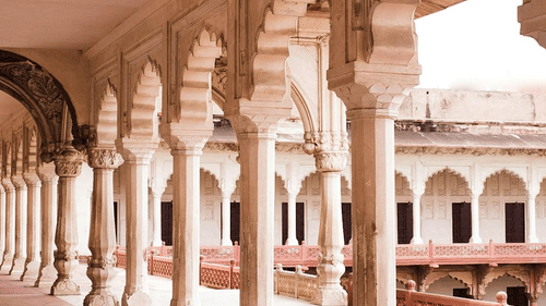 Arched corridor in a historic haveli with intricate architectural details.