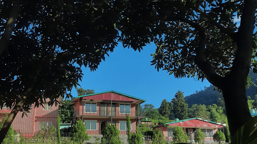 Facade of Neer Ganga Resorts with a canopy cover in the garden
