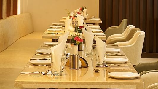 A linear seating arrangement with a warm lighting and lights dropped from the ceilings at The Hamuse Hotel, Kodaikanal.