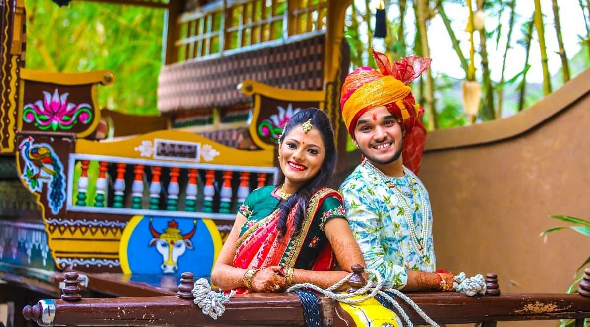 image of a young couple fully dressed in regional ethnic outfit posing in front of the bullock cart 