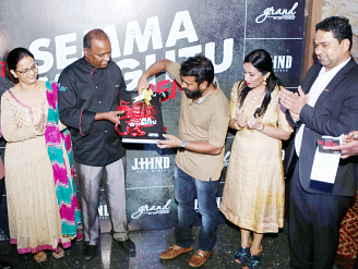 Group of people at a ribbon-cutting ceremony, marking the opening of an event.