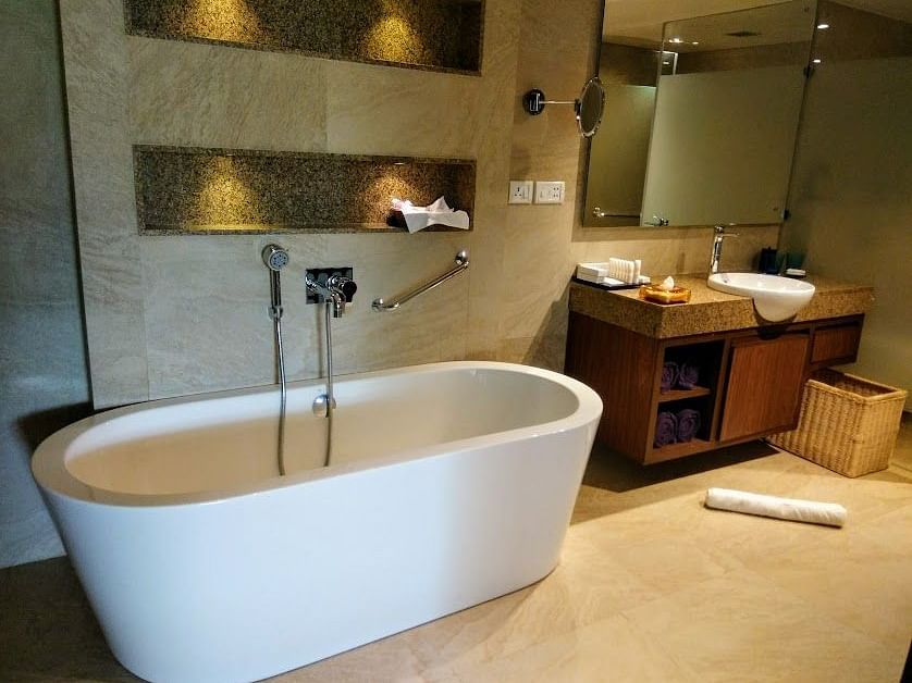 An interior view of a bathtub with a cabinet and a mirror.
