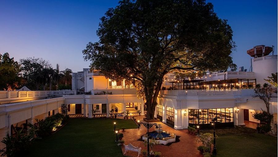 Image showing a large tree in front of a bespoke residence with a fountain, carefully put together on a lawn.