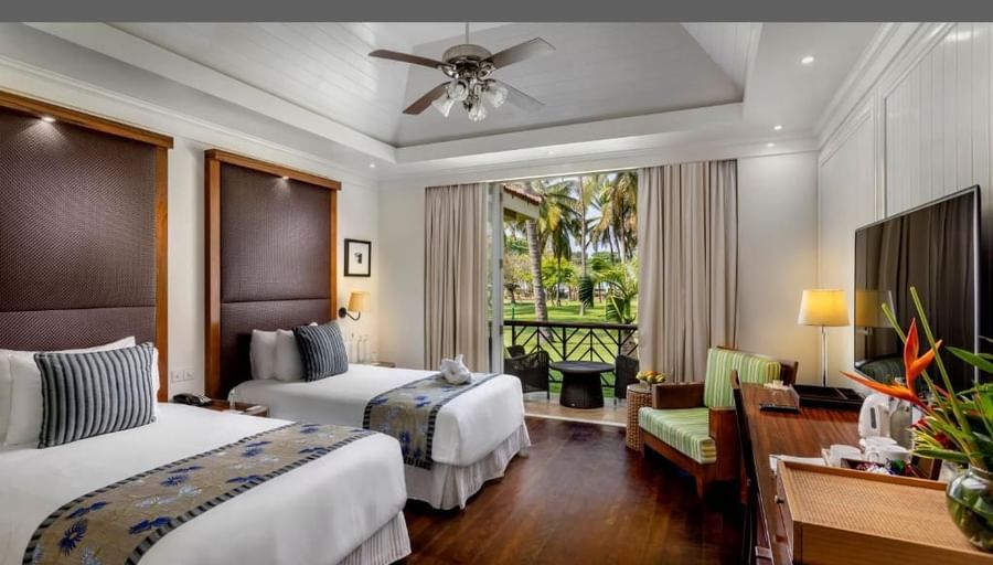 twin bed with a tv opposite it inside of the rooms - Caravela Beach Resort Goa