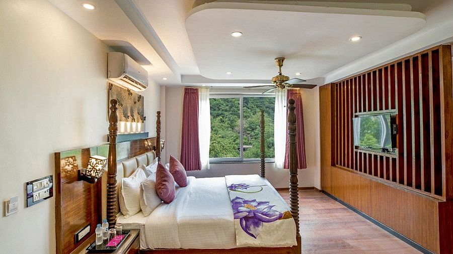 Side view angle of a bedroom with a double bed with bed side tables besides it at Regenta Inn DLS.