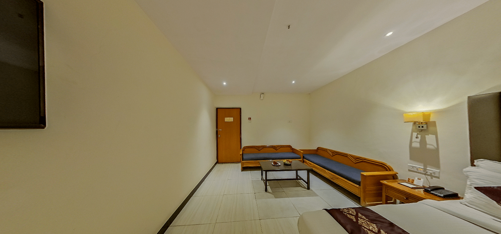 Spacious family room at Lords Eco Inn Dahej with L-shaped seating, coffee table, additional beds, and premium hospitality features