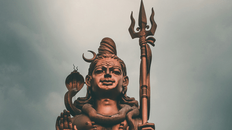 An overview of a Statue of Belief (Nathdwara) covered in Bronze with a tree in the background.