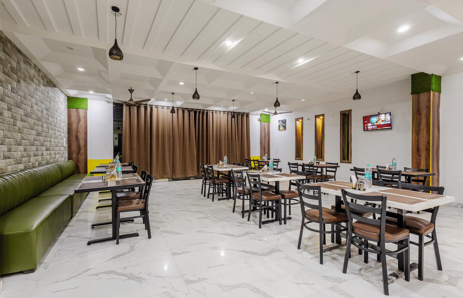 The indoor restaurant at Lime Tree Hotels and Banquet, Vrindavan with well defined seating area.