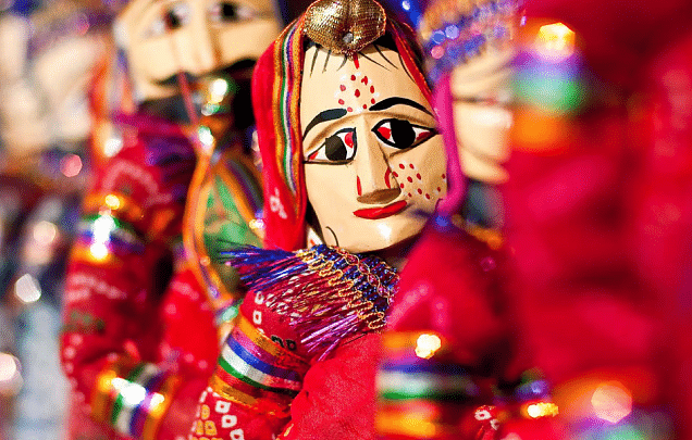 A close-up shot of traditional Rajasthani puppets, with a female puppet in focus.