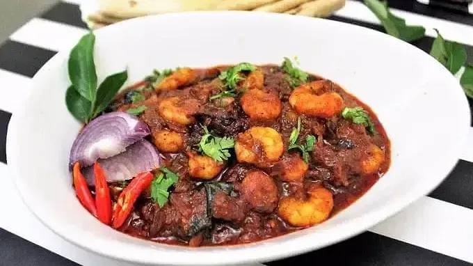 Fried Masala Prawns placed on a surface next to chappati at Indie Stays Resort, Goa.