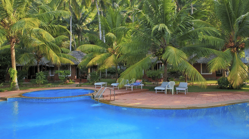 An overview of the swimming pool with loungers in view - Abad Harmonia, Kovalam.