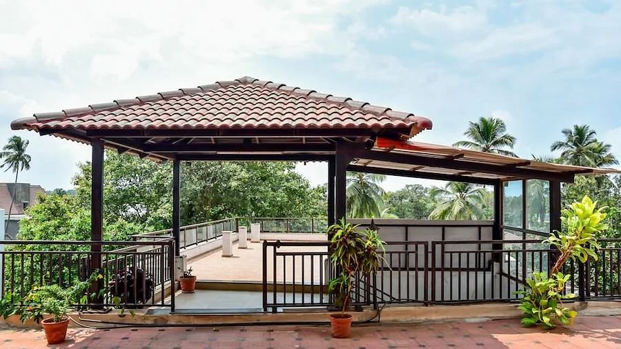 Covered outdoor seating area near a pool at La Vida Studio Inn Goa.