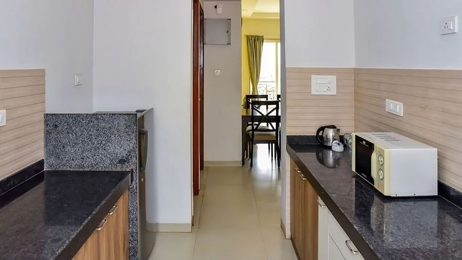 Kitchenette area with a microwave and sink at La Vida Studio Inn Goa.