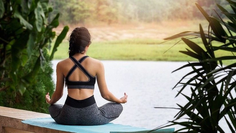 a girl doing yoga in front of a pool