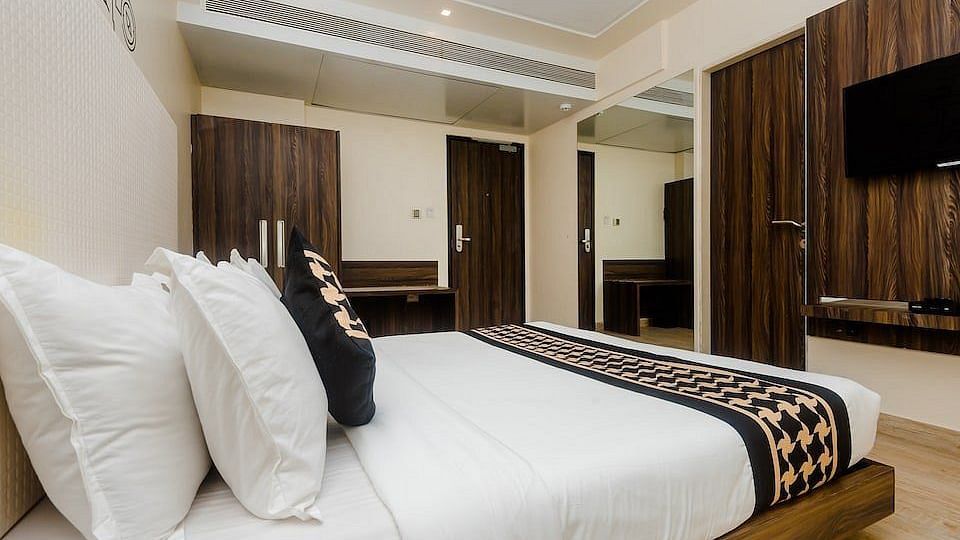 Deluxe room at Mumbai House Hotel, Juhu with a double bed and a television