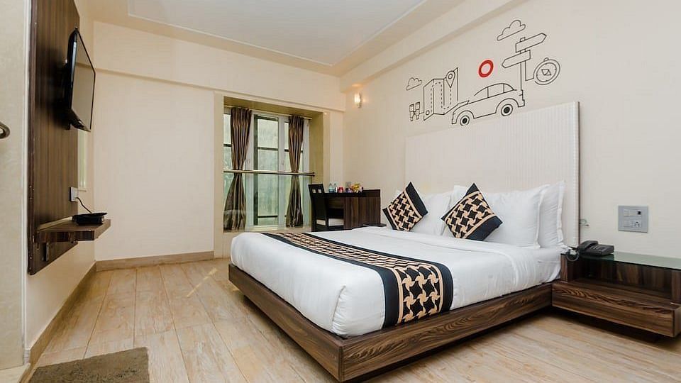 Deluxe room at Mumbai House Hotel, Juhu with a double bed and a television
