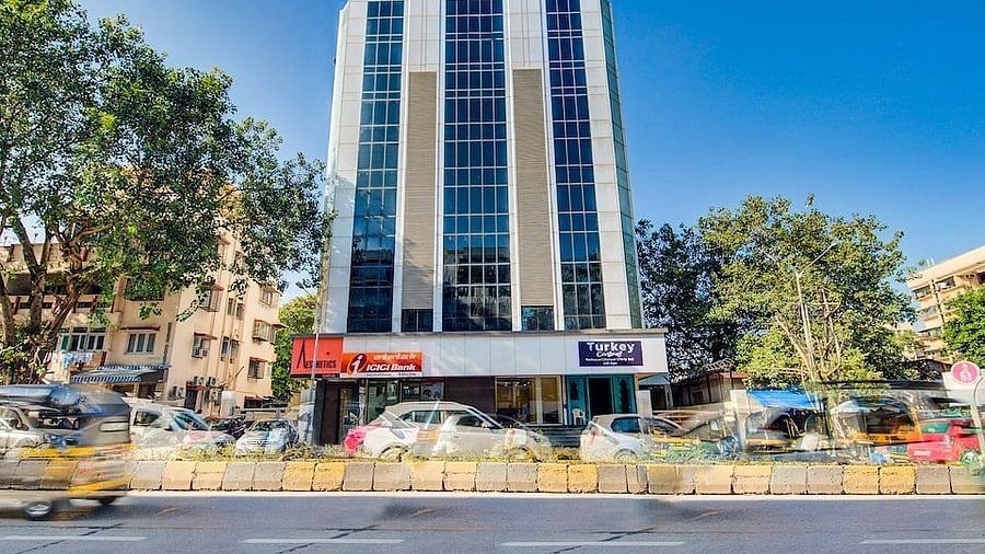 Facade of Mumbai House Hotel, Juhu on a clear, blue day