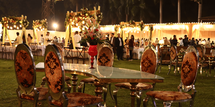 Outdoor seating setup at The Sonnet with round tables, chairs, and evening lights.