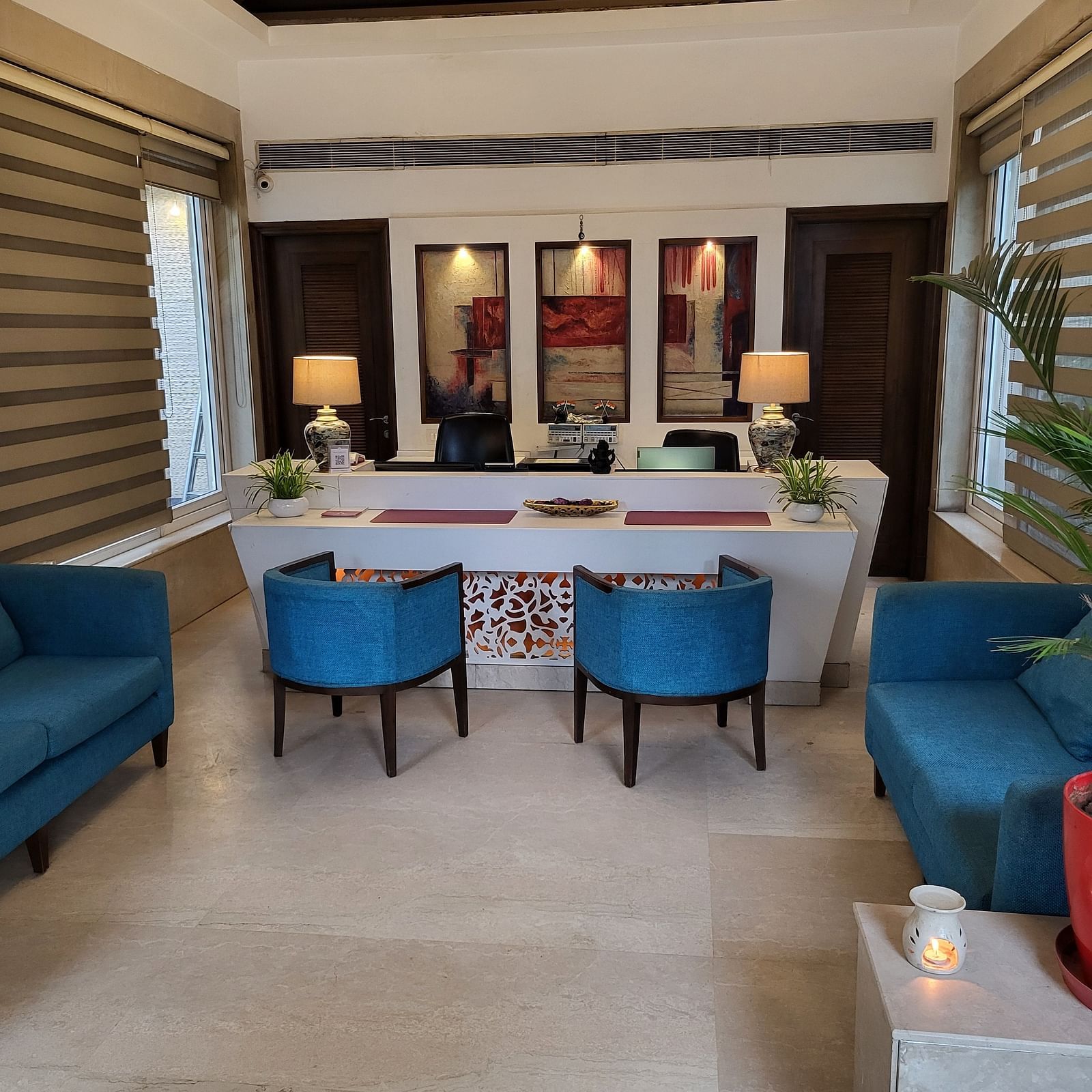 An image of a reception lobby featuring sofas, chairs, reception desk, and lights hanging from the ceiling - Inde Hotel Signature Tower Gurgaon
