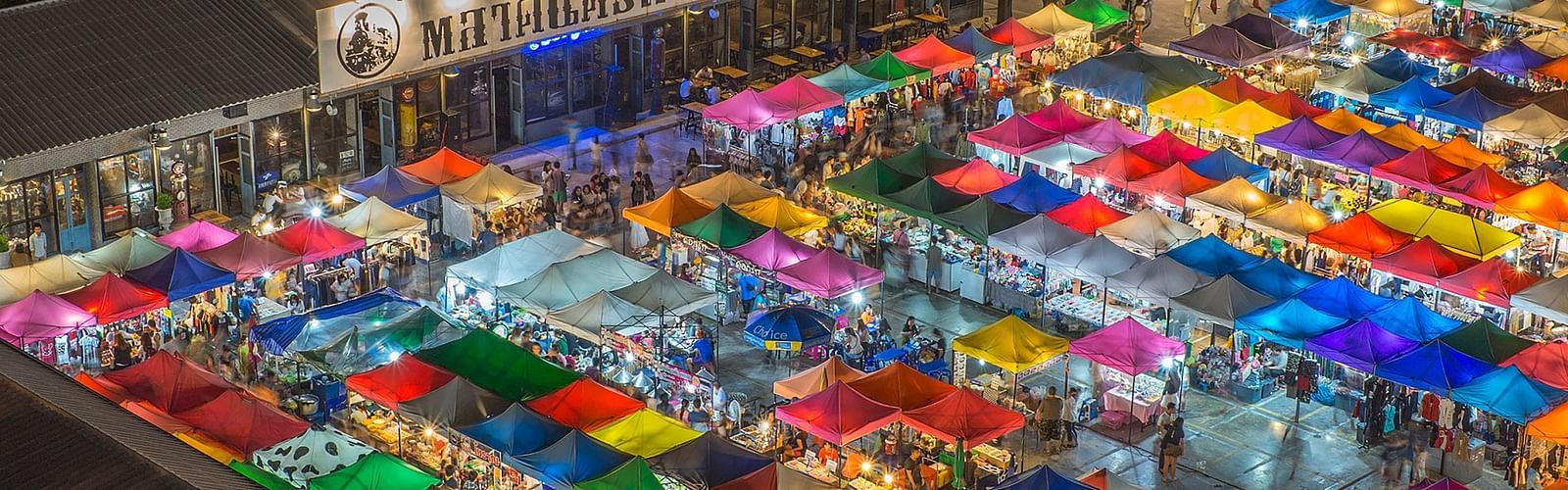 an aerial view of a night market with many shops and people in view.
