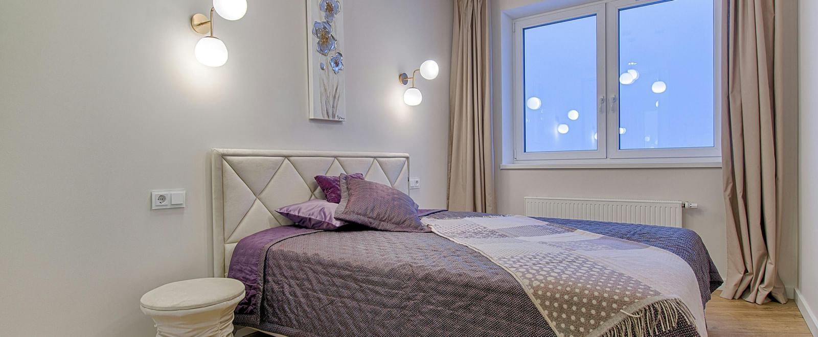 A modern bedroom with a double bed, light walls, and minimalist furniture.