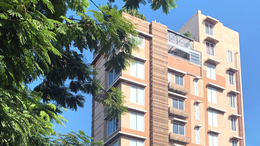Facade of Theory9 Service Apartments in Bandra during the day with trees in view.