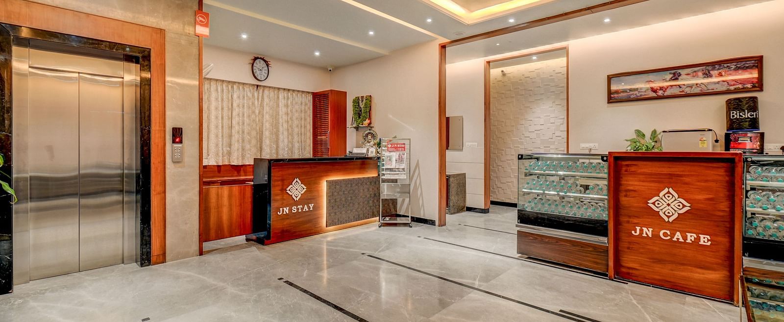 The reception area at Harigovinda's JNStay, featuring two desks and a lift to the side