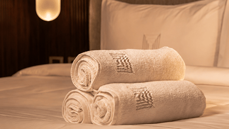 Warm Luxury Hotel Bed with Rolled Towels