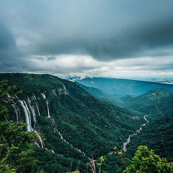 an aerial view of the many waterfalls cascading down from a mountain side in Cherrapunji