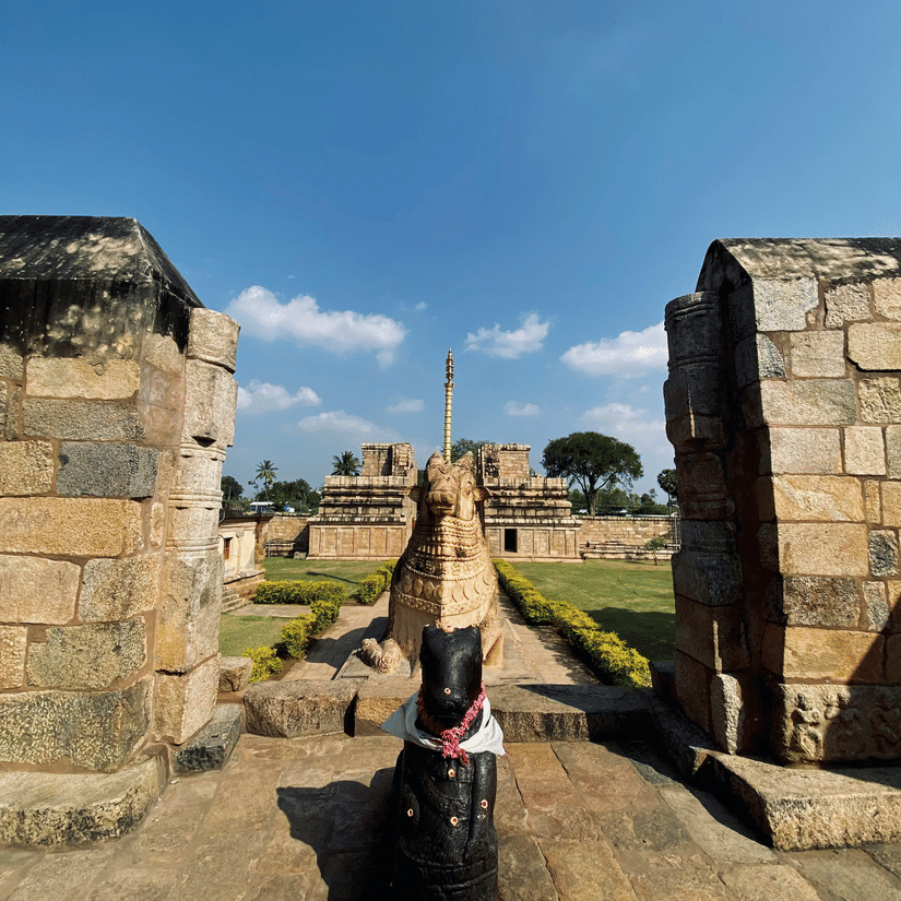 A close up of a black sculpture in the centre with an open space between the walls behind it at Brihadeeswarar Temple in Thanjavur.