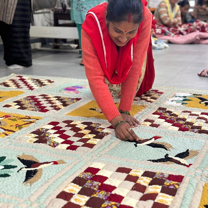 Image of a lady making rangoli on the floor