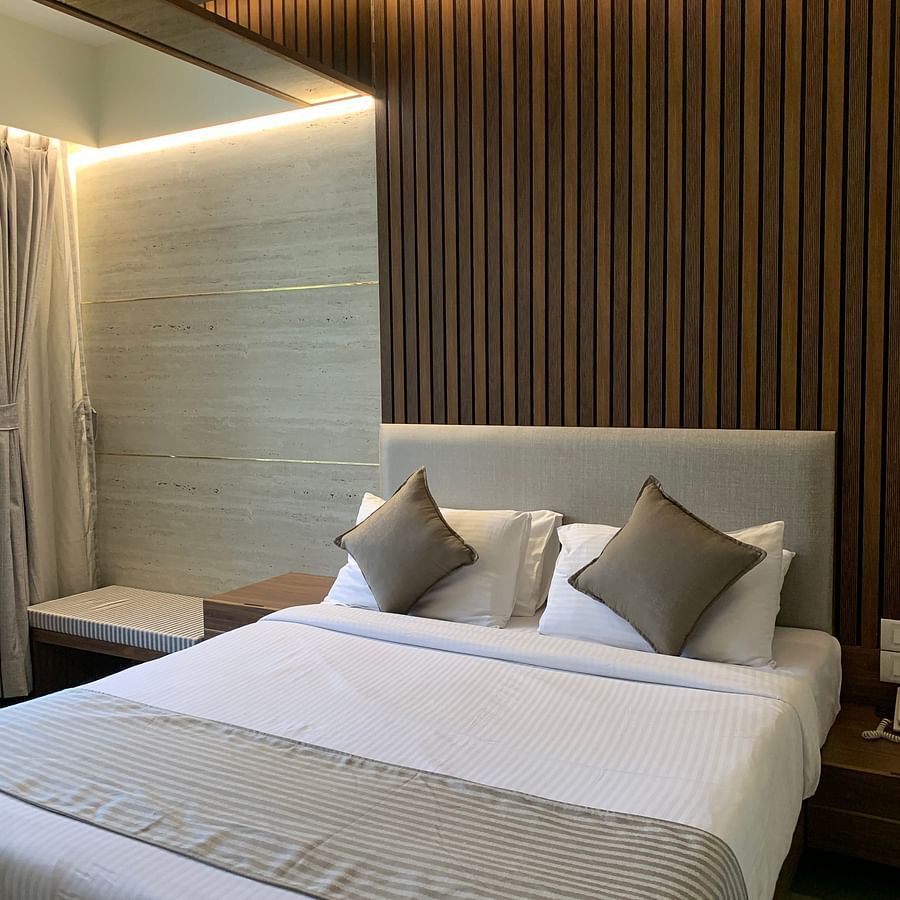 a king size bed being pillows and a duvet offered at the stable facing room in Khandala - Zara's Resort