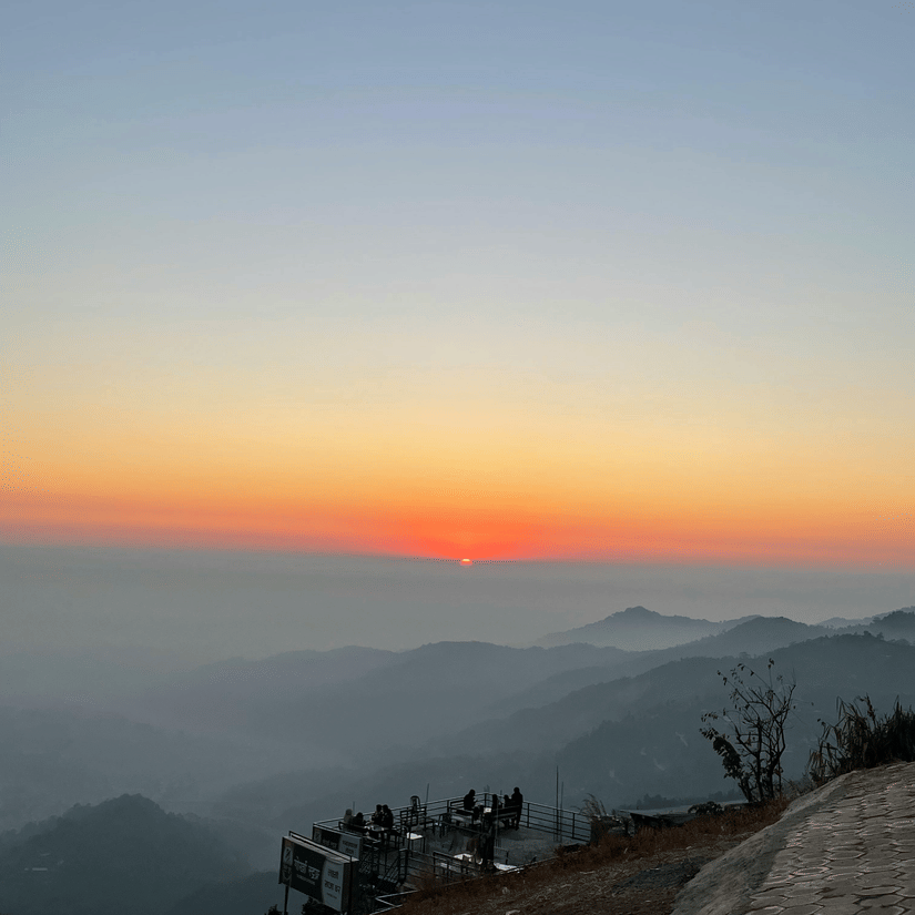 Soft dawn colours spreading across layered mountain ridges in the Himalayas.