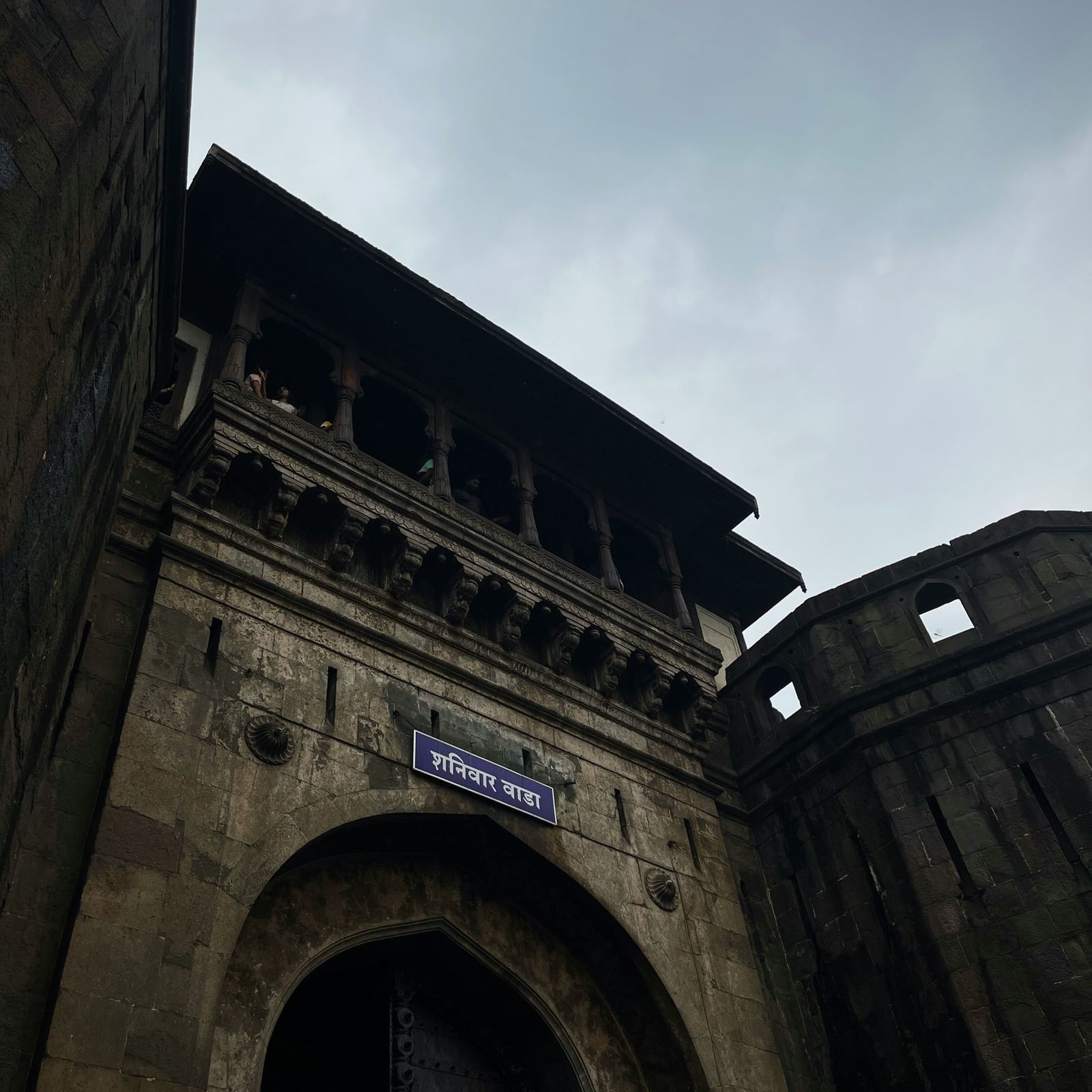  A close-up, low-angle shot of the ornate stone entrance gate of a historic building.