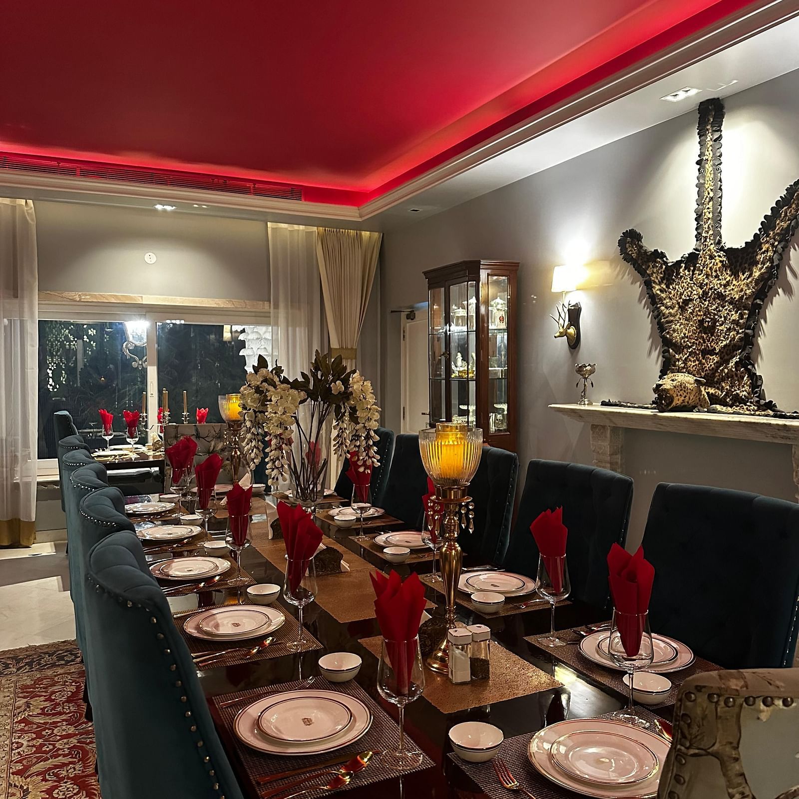 Elegant dining setup at Dileep Kothi with plush chairs, neon-lit red ceiling, and authentic Rajasthani food in Jaipur.