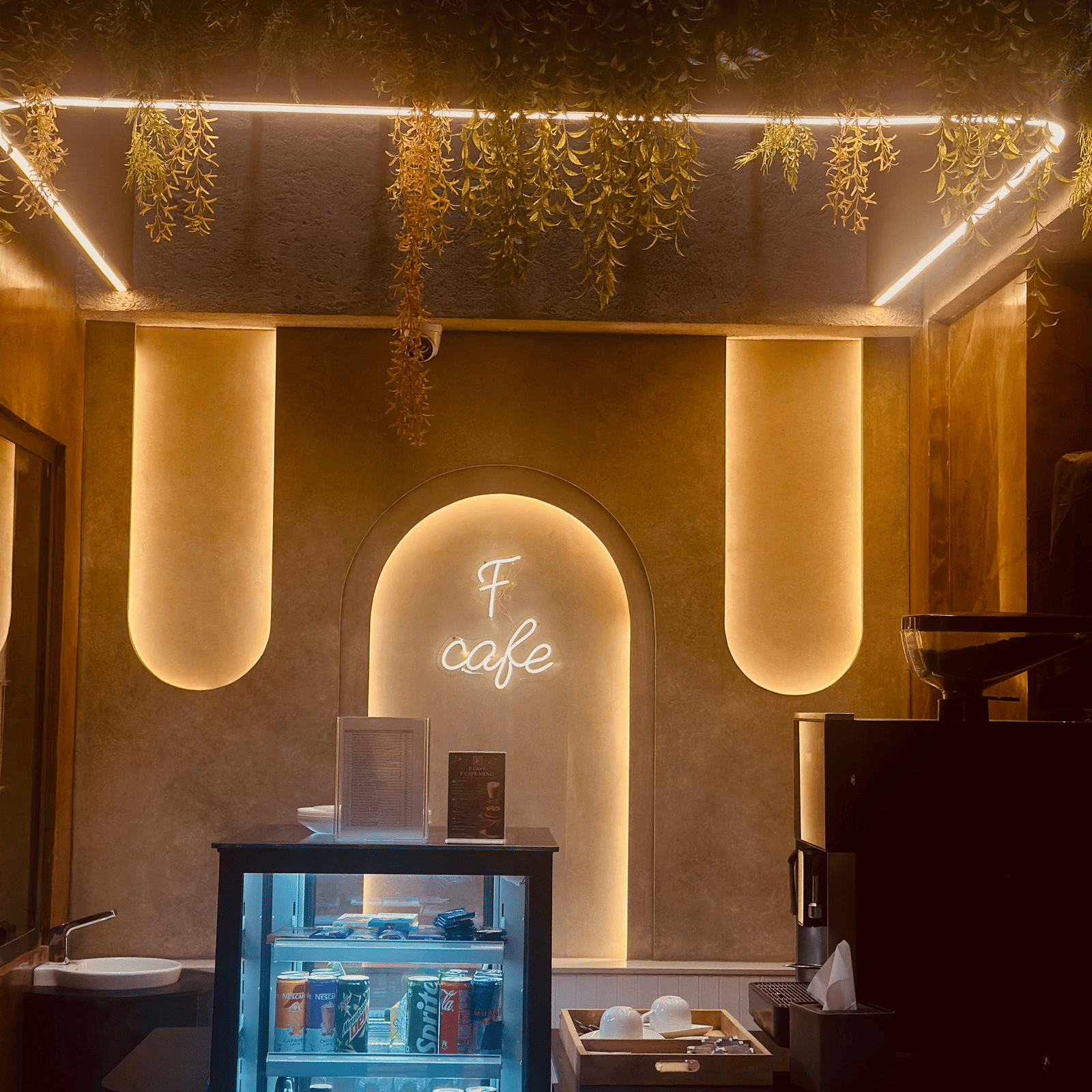 Front view of the F Cafe featuring a mini fridge with transparent door at F Hotels, Bengaluru.