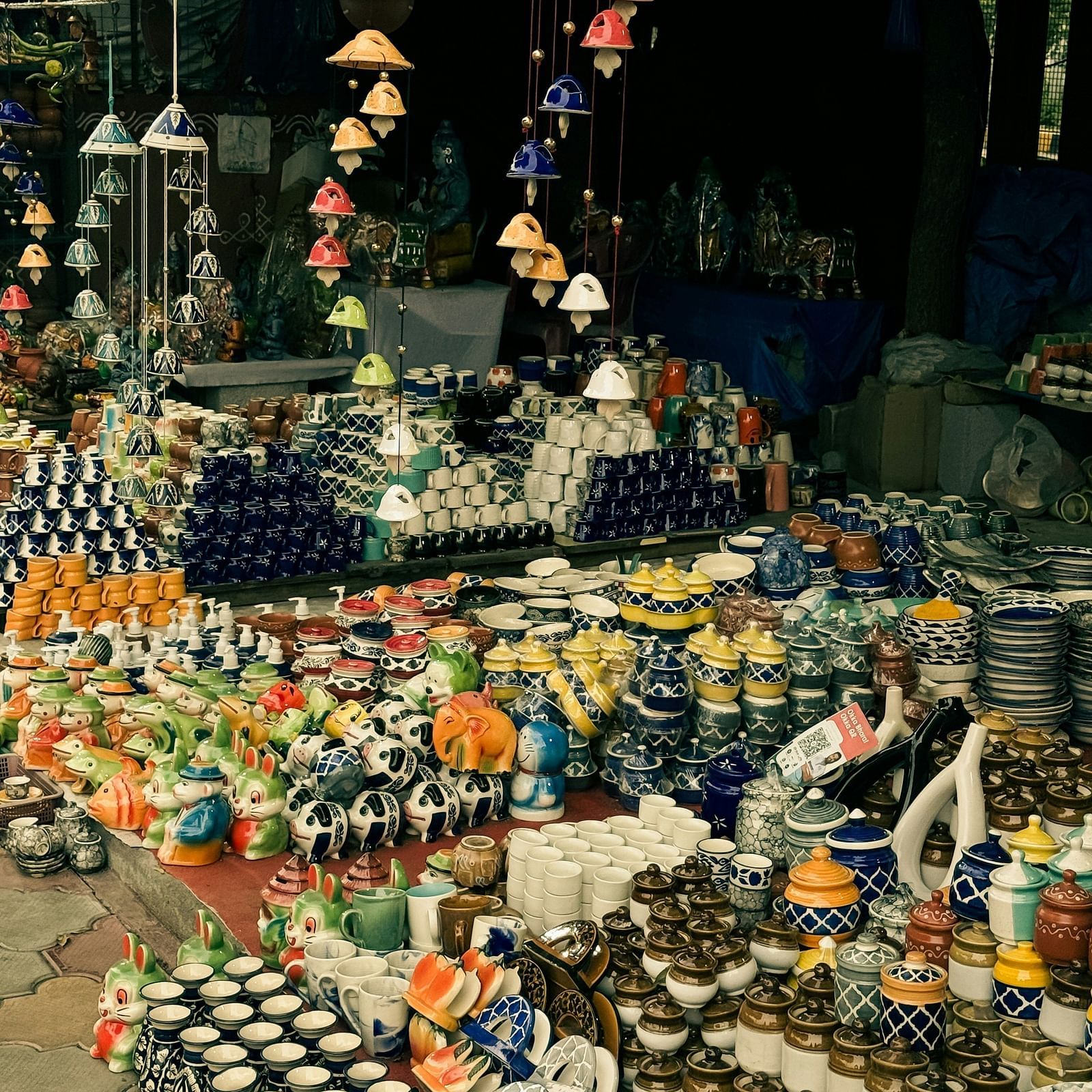 Market place in broad daylight with various china materials and art works kept in display for sale.