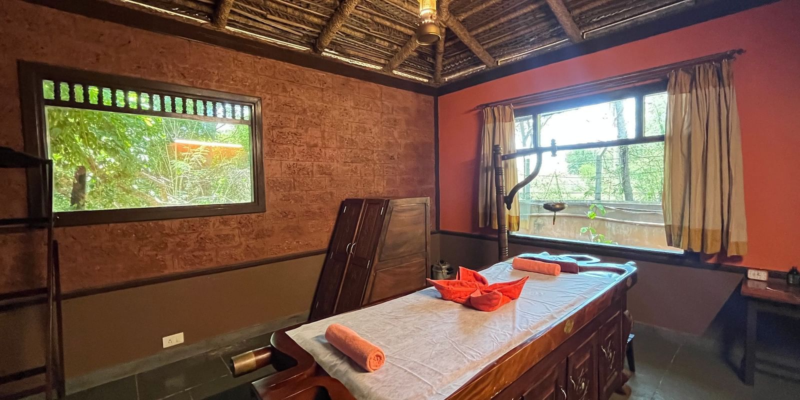 full view of the ayurveda spa room at hoysala village resort featuring the bed in the middle.