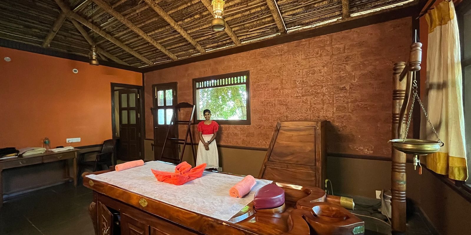 interior of the ayurveda spa with a wooden bed with soft towels in the middle with enchanting aromoas of incess sticks at hoysala village resort in hassan