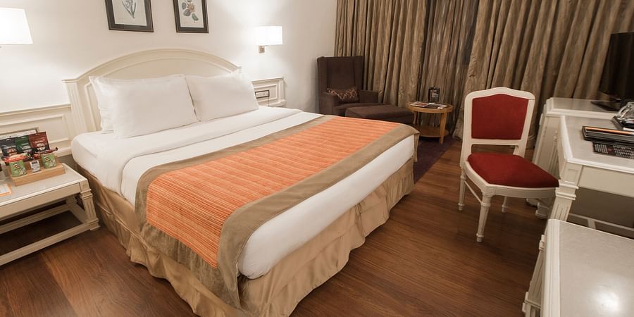 room with king size bed and wooden flooring at hotel bawa international