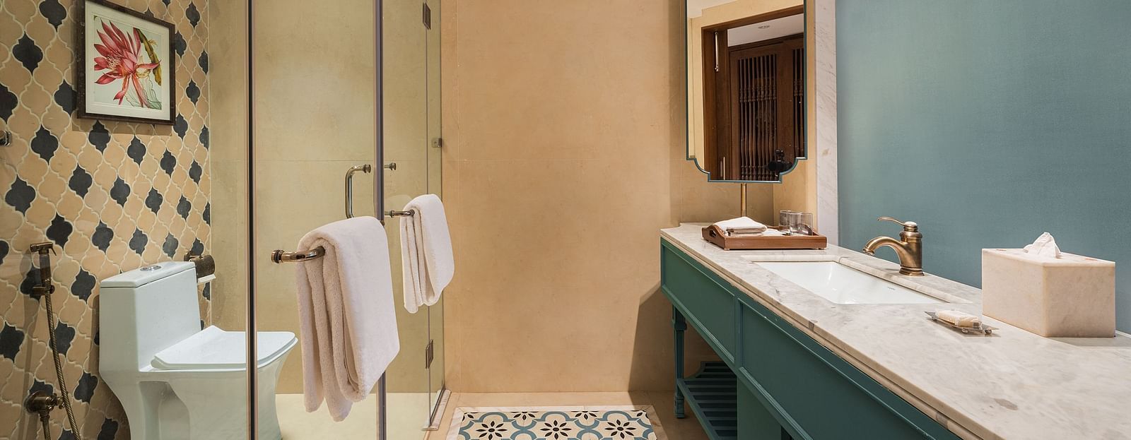 Premium Suite wash room of naini retreat, nainital, modern and spacious bathroom with a glass shower, a large vanity with a marble counter top, and a patterned floor tile. 